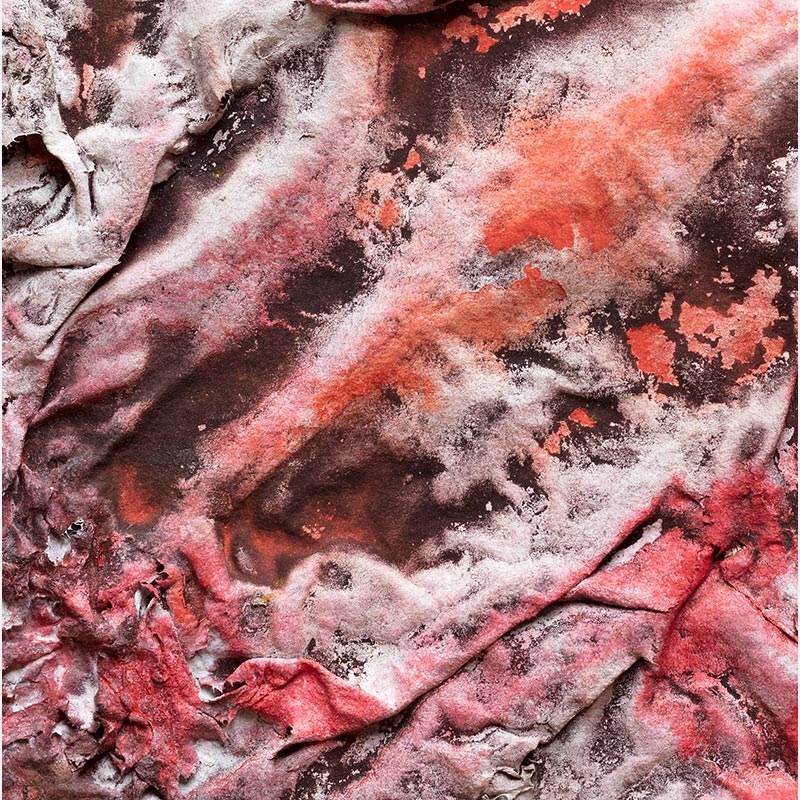 Detail of an abstract textural work on paper. Mainly red and brown colors. Title: Pompeii Papyrus