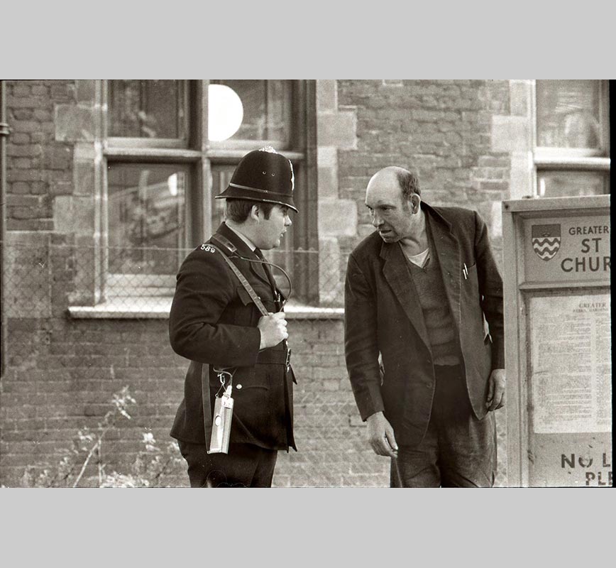 Black and white photograph of a British policemen and a shabby man in London in the 1960s. Limited edition print. Title: Untitled
