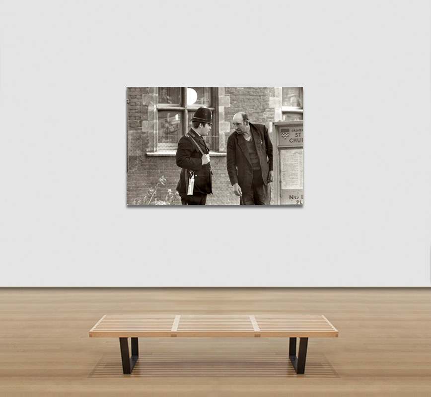 View in a room of a Black and white photograph of a British policemen and a shabby man in London in the 1960s. Limited edition print. Title: Untitled