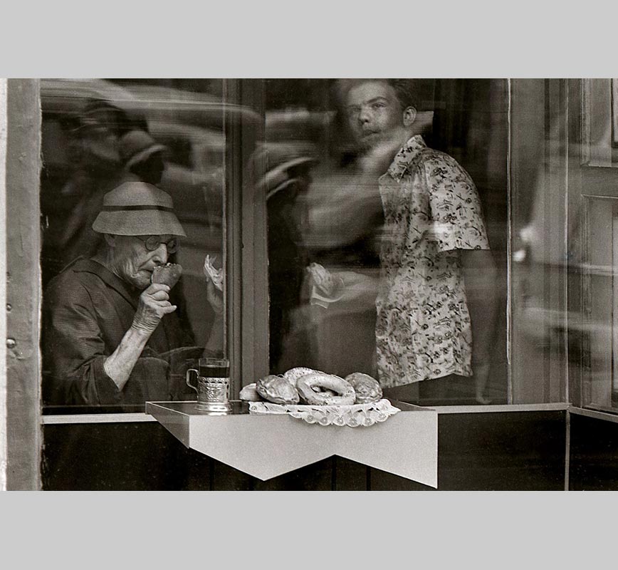 Black and white photograph of people seen through a window in 1967 in Moscow, USSR. Limited edition print. Title: Breakfast, Moscow, 1967